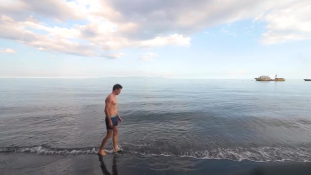 Fit man w lecie krótki spacer w tę i z powrotem na plaży w gorący letni dzień. — Wideo stockowe