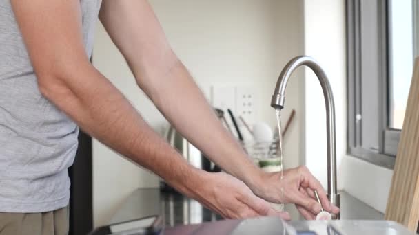 El hombre se lava las manos con agua corriente en el grifo . — Vídeos de Stock