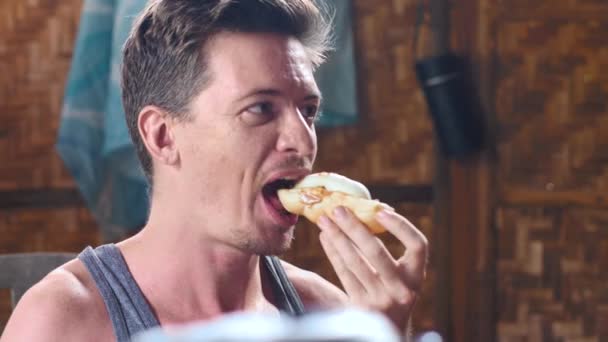 Portrait of a man savoring a delicious sandwich with peanut butter and banana. — Stock Video