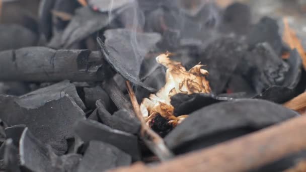 Brennendes Papier auf Holzkohle zum Grillen. Papier brennt auf glühenden Kohlen. — Stockvideo