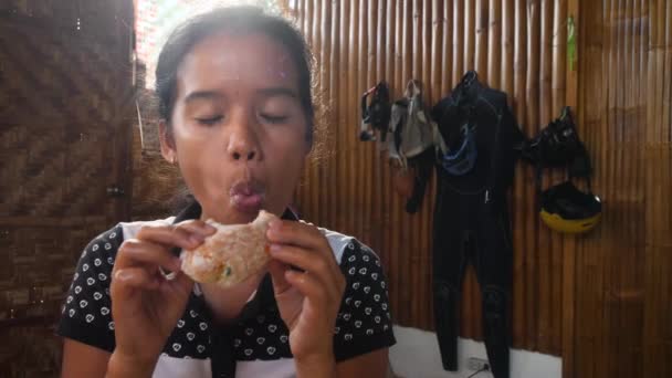Una chica feliz disfrutando de un delicioso donut dulce . — Vídeos de Stock