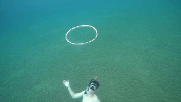 Ein männlicher Freitaucher unter Wasser und ein Blasenring, der in Zeitlupe aufsteigt. — Stockvideo