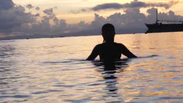 Silueta mladé ženy koupající se v oceánu za úsvitu. — Stock video