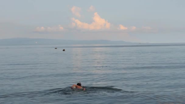 Young man with snorkeling mask go swimming in the peaceful ocean. — Stock Video