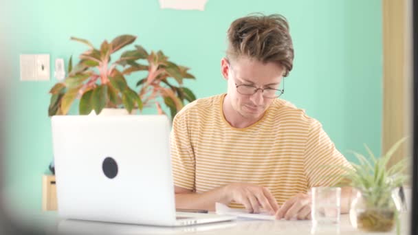 Fokuserad ung man frilansare student studerar online eller arbetar hemifrån. — Stockvideo