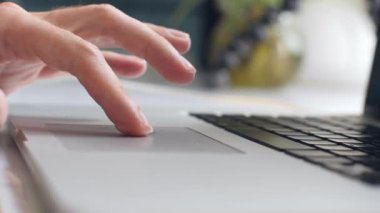 Man 'in ellerinin, dizüstü bilgisayarı kullanarak bir web sitesini kaydırırken yakın plan görüntüsü..