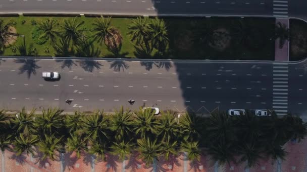 Vista de arriba hacia abajo sobre una carretera de cuatro carriles con pocos coches y bicicletas en marcha . — Vídeos de Stock