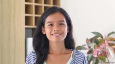 Güzel, güler yüzlü, kendinden emin Filipinli kadın. Güzel yüz kameraya bakıyor.