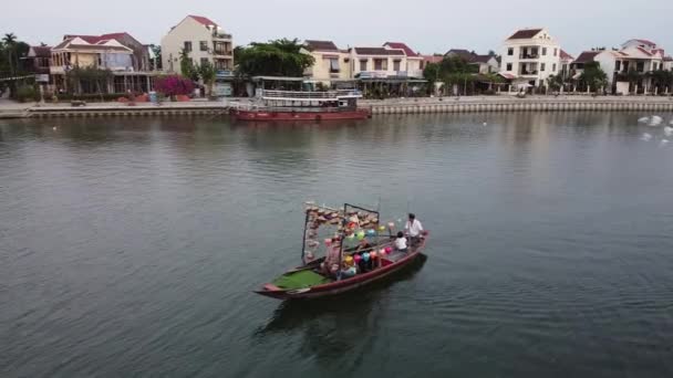 Nehirde yelken açan renkli fener süslemeleri olan turist teknesinin insansız hava aracı görüntüsü. — Stok video