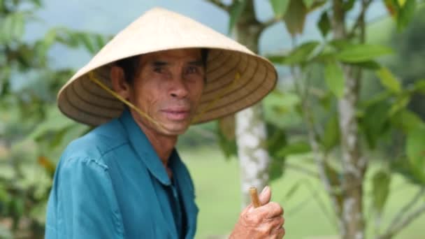 Hue, Vietnam- 05 02 2020: Ett porträtt av en lycklig bonde i vietnamesisk hatt. — Stockvideo