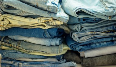 farklı renkler ve renk tonlarının katlanmış kot yığını