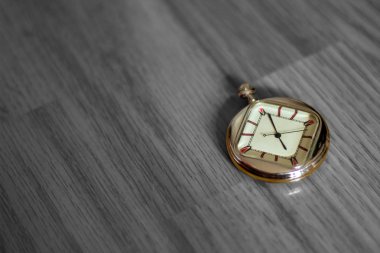 Siyah Beyaz ahşap dokulu zemin üzerinde yalan renkli cep saati