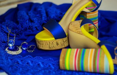      kadın sandalet mavi gece elbisesi parlak aksesuarları ile mavi arka plan üzerinde yüksek topuk ile