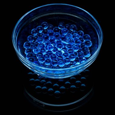 Siyah bir arka plan üzerinde izole bir cam vazo içinde mavi hidrojel topları