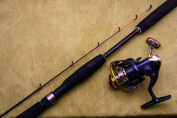 Vara giratória com carretel de pesca no fundo de encerado. Pesca atacar no fundo de lona . — Fotografia de Stock