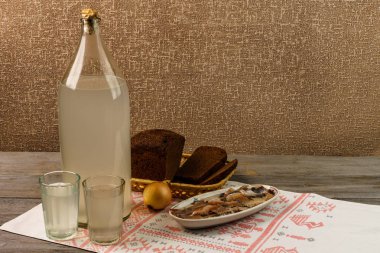 Ukrayna Ulusal içecek ve aperatif. Büyük şişe ve bardak kaçak içki eski ahşap tablo