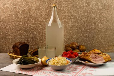 Ukrayna Ulusal içecek ve aperatif. Büyük şişe ve bardak kaçak içki eski ahşap tablo 