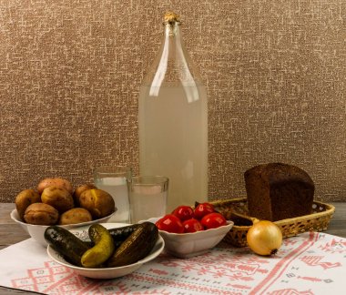 Ukrayna Ulusal içecek ve aperatif. Büyük şişe ve bardak kaçak içki eski ahşap tablo 