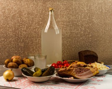 Ukrayna Ulusal içecek ve aperatif. Büyük şişe ve bardak kaçak içki eski ahşap tablo 