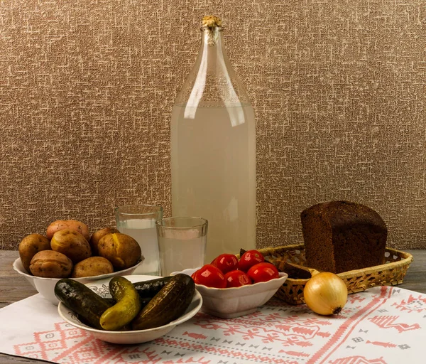 Ukrayna Ulusal içecek ve aperatif. Büyük şişe ve bardak kaçak içki eski ahşap tablo 