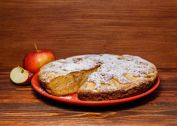 Manzanas frescas y un trozo de tarta de manzana espolvoreada con su polvo — Foto de Stock