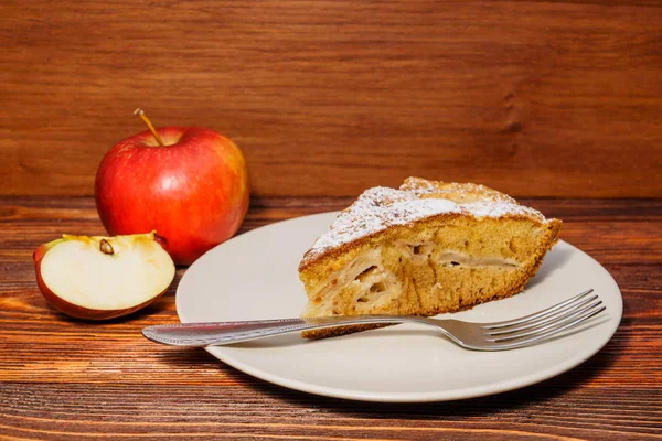 Manzanas frescas y un trozo de tarta de manzana espolvoreada con su polvo — Foto de Stock