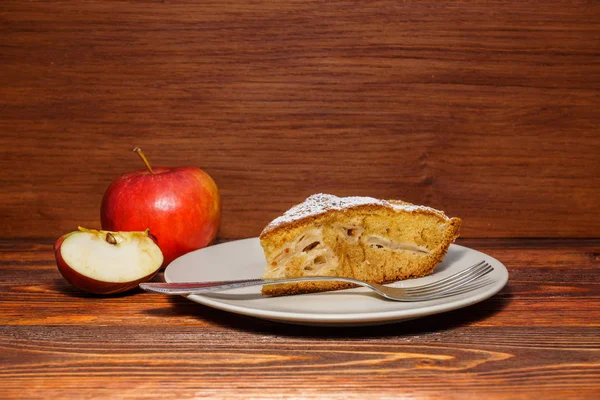 Manzanas frescas y un trozo de tarta de manzana espolvoreada con su polvo — Foto de Stock