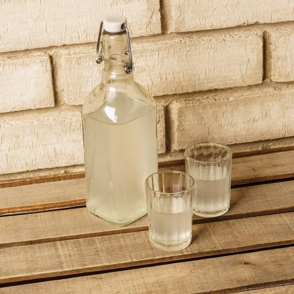 La botella de vodka y dos vasos al aire libre. Botella y sho —  Fotos de Stock