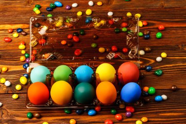 Lezzetli renkli Paskalya yumurtaları ve tatlılar ahşap bac üzerinde