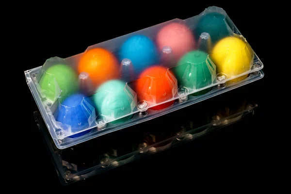 Un grupo de huevos de Pascua frescos y coloridos en una bandeja de plástico transparente, i — Foto de Stock
