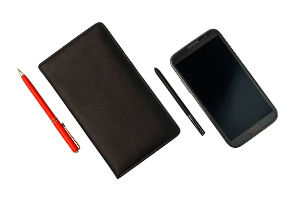 Uno smartphone con penna stilografica e un notebook nero con penna rossa — Foto Stock