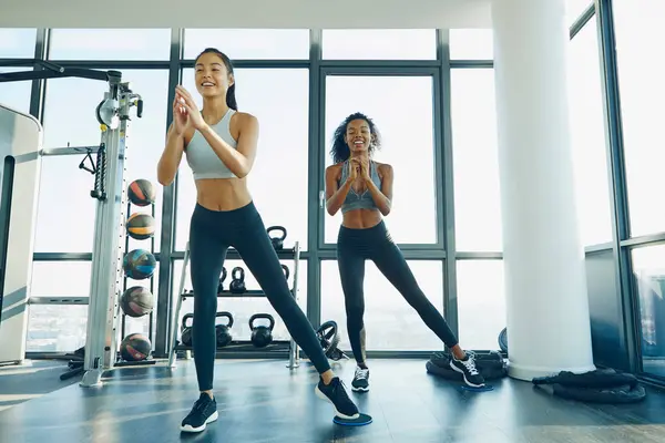 Dos mujeres jóvenes haciendo ejercicio en el gimnasio — Foto de Stock