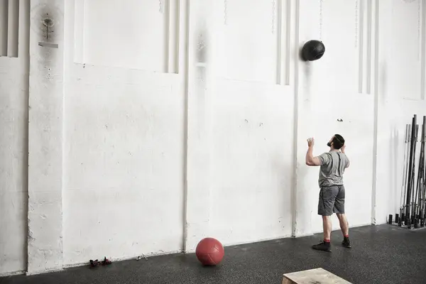 Hombre lanzando pelota de fitness — Foto de Stock