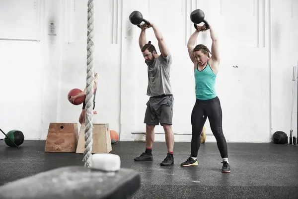 Paar trainiert mit Kettlebells — Stockfoto