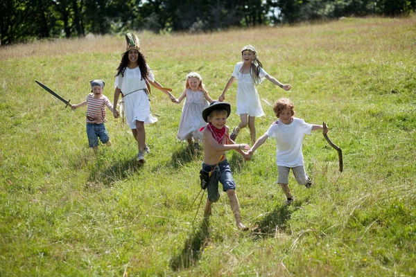 Children in costumes running in field — Stock Photo, Image