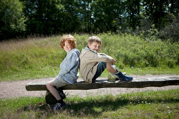 Two boys sitting on wooden bench — Stock Photo, Image