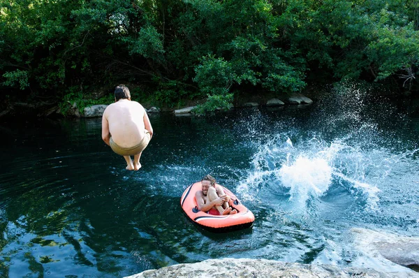 Men jumping in forest lake — Stock Photo, Image