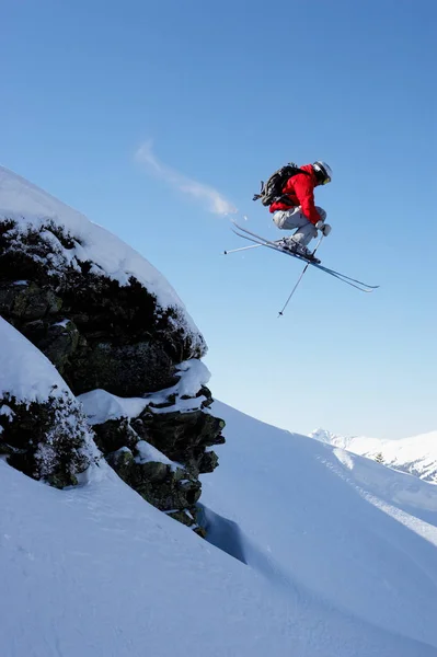 岩を飛び越える男性スキーヤー — ストック写真