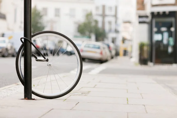 Rueda de bicicleta única fijada al poste de la lámpara — Foto de Stock