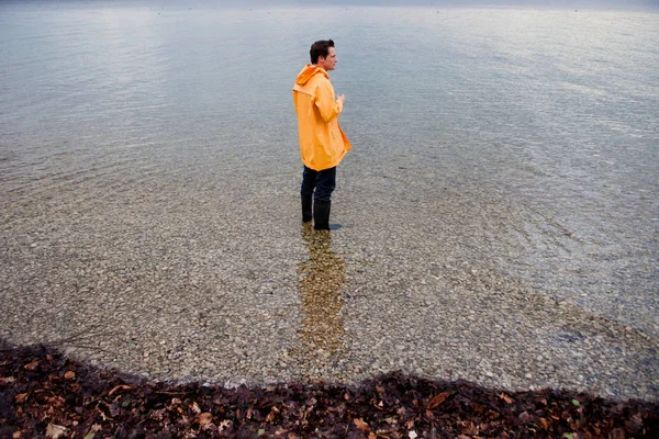 Man Raincoat Shallow Water — Stock Photo, Image