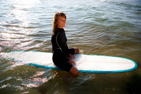 Kobieta Siedzi Deskę Surfingową Uśmiechnięty — Zdjęcie stockowe