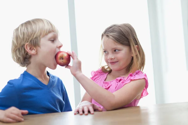 台所でリンゴを食べる子供たち 前景に焦点を当てる — ストック写真