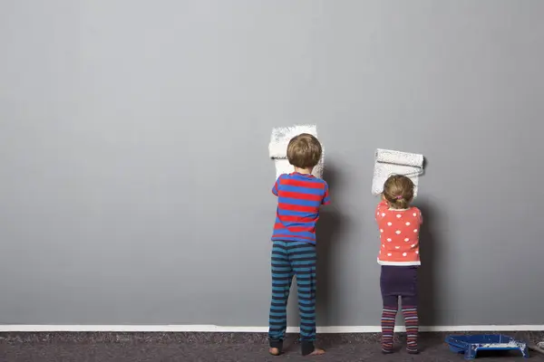 Rückansicht Von Bruder Und Kleinkind Schwester Beginnt Wand Bemalen — Stockfoto