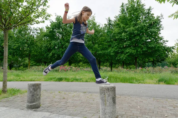 Girl Jumping Bollards Mid Air Park — Stock Photo, Image