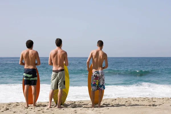 Tre Giovani Sulla Spiaggia Con Tavole Surf — Foto Stock