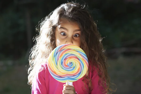 Portrait Girl Crossing Eyes Lollipop Front Her Face Garden — Stock Photo, Image