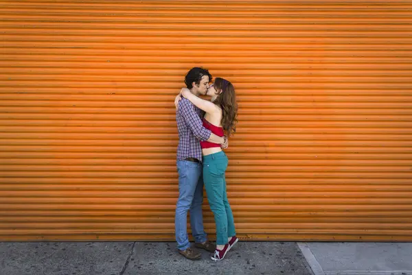 Casal Romântico Beijando Frente Obturador Laranja — Fotografia de Stock