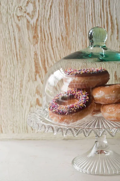 Doughnuts under glass jar — Stock Photo, Image