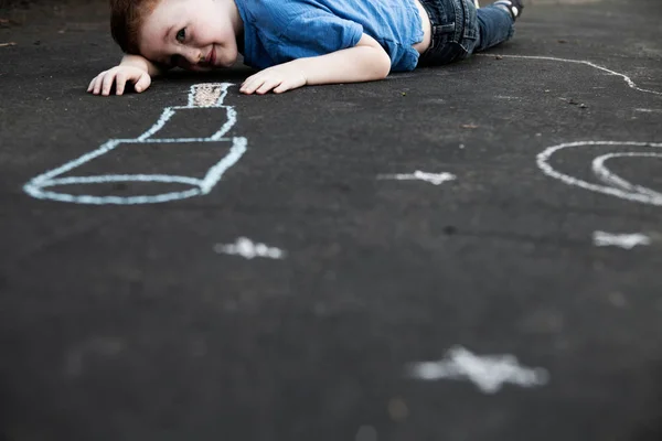Junge Liegt Auf Dem Boden Und Betrachtet Kreidezeichnung — Stockfoto