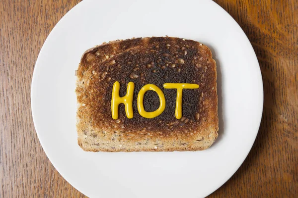最热门的字热写在烤面包芥末 — 图库照片